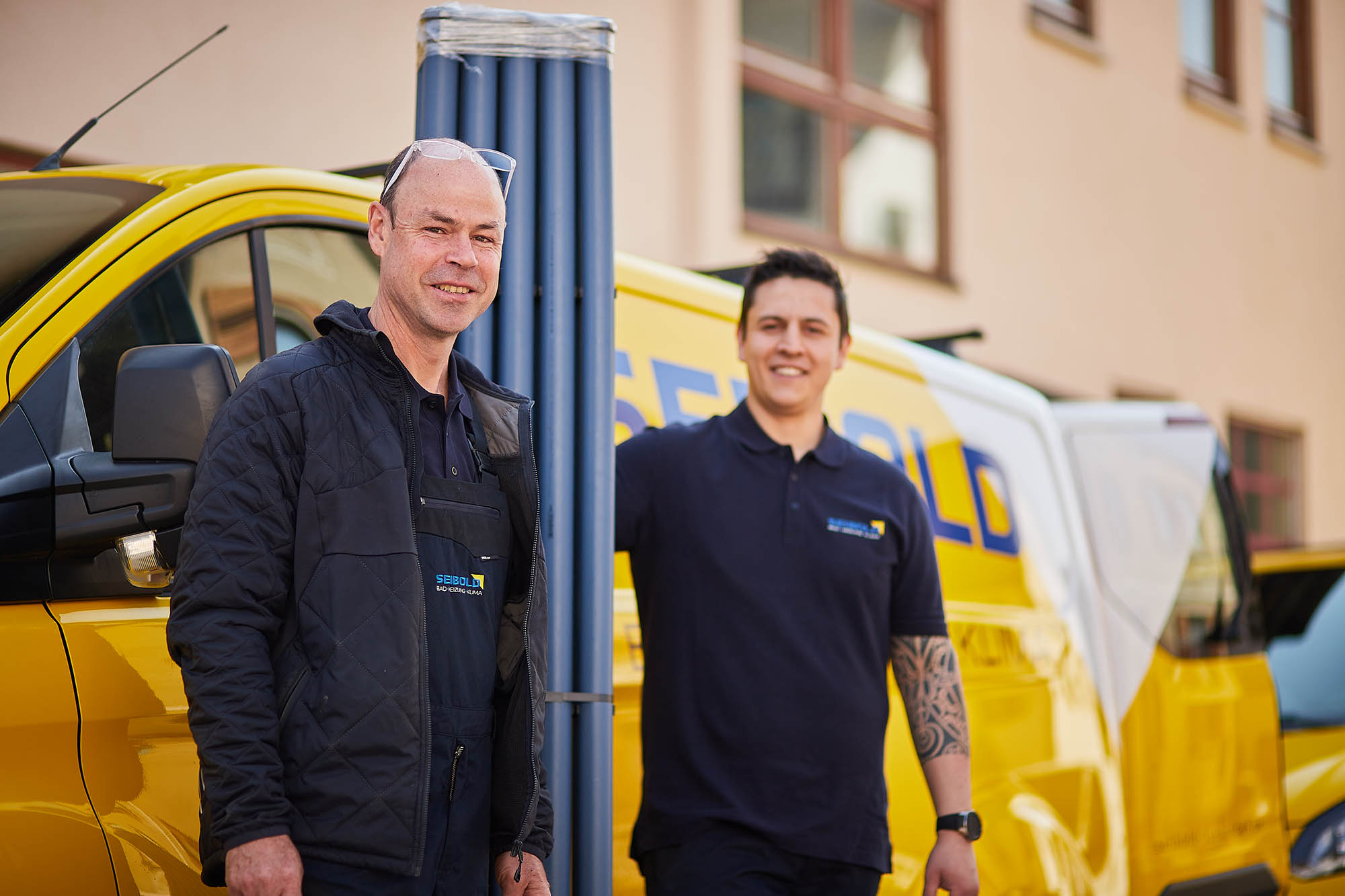 Seibold Mitarbeiter vor Firmenfahrzeug mit Kunststoffrohre